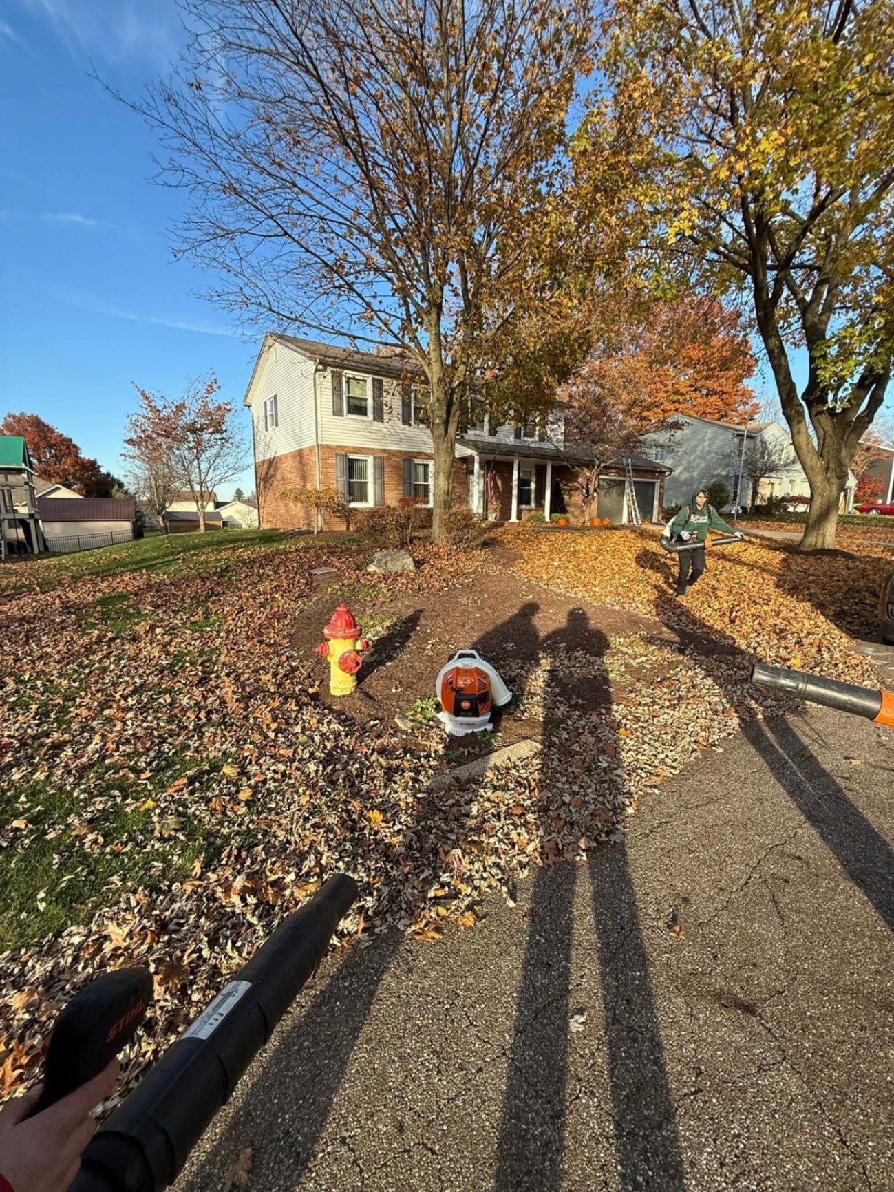 Crew blowing fall leaves off a residential lawn in Canton, OH